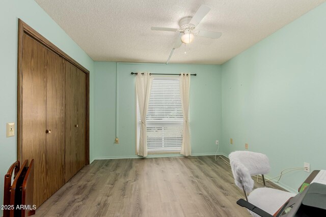 office with ceiling fan, light hardwood / wood-style flooring, and a textured ceiling