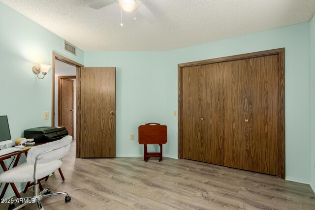 office space featuring ceiling fan, a textured ceiling, and light hardwood / wood-style floors