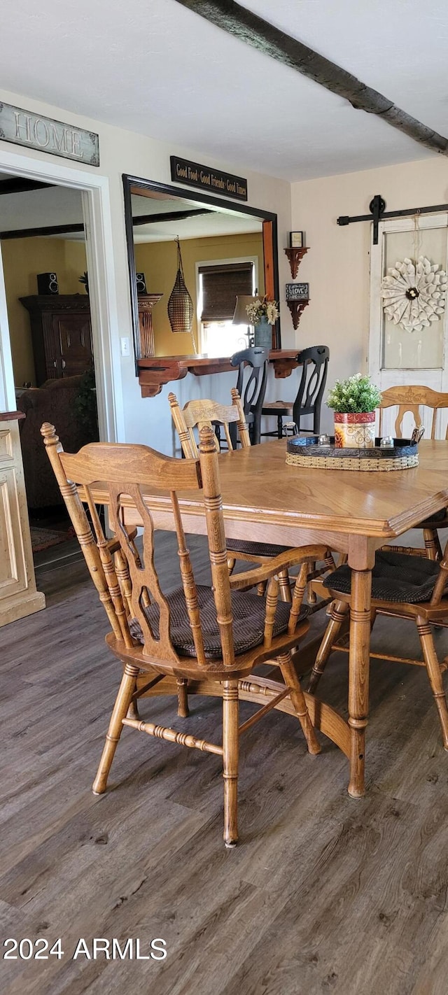 dining area featuring a barn door and wood-type flooring