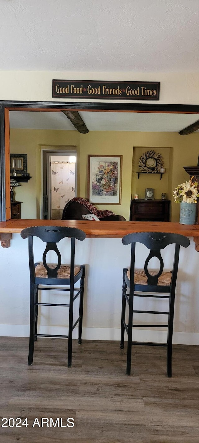 bar featuring hardwood / wood-style flooring and a textured ceiling