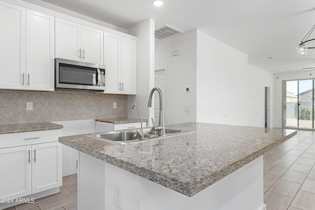 kitchen featuring sink, a center island with sink, white cabinetry, and ceiling fan