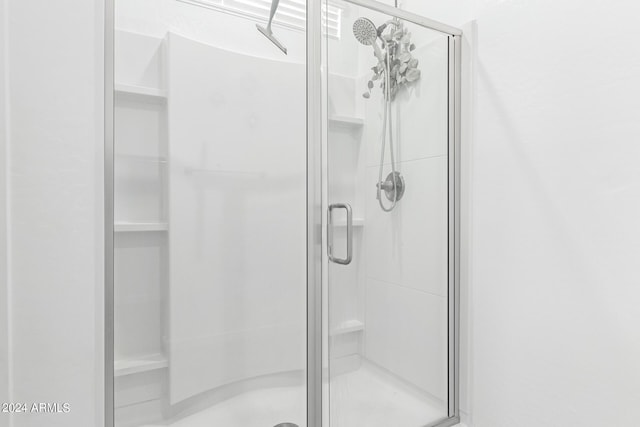 bathroom featuring a shower with door