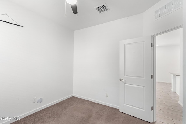 carpeted spare room with ceiling fan