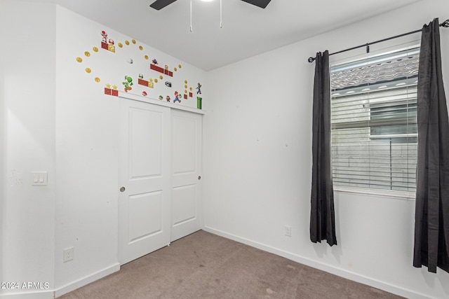 unfurnished bedroom featuring ceiling fan and carpet floors