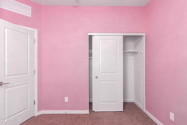 unfurnished bedroom featuring light colored carpet and a closet