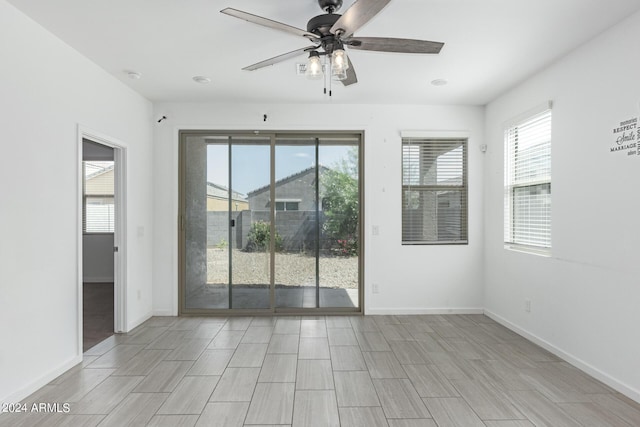 spare room with ceiling fan and a healthy amount of sunlight