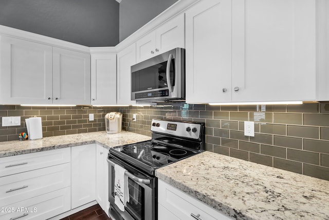 kitchen with stainless steel appliances, white cabinets, light stone countertops, and backsplash