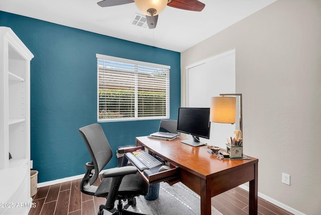home office with wood tiled floors, baseboards, and a ceiling fan