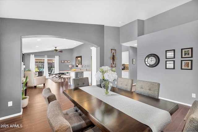 dining area with arched walkways, a ceiling fan, wood finished floors, baseboards, and recessed lighting