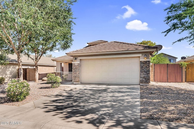 prairie-style house with stone siding, stucco siding, driveway, fence, and an attached garage