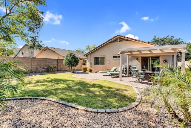 rear view of property featuring stucco siding, a pergola, and a patio area