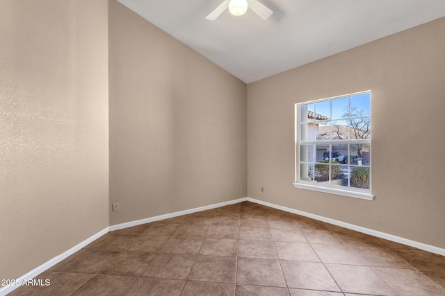 spare room with tile patterned floors, vaulted ceiling, and ceiling fan