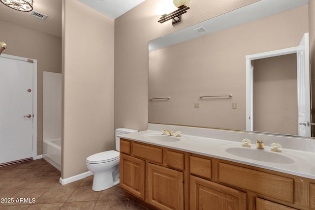 bathroom with a tub to relax in, toilet, vanity, and tile patterned flooring