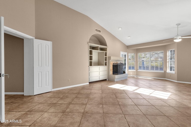 unfurnished living room featuring light tile patterned flooring, a multi sided fireplace, ceiling fan, high vaulted ceiling, and built in features