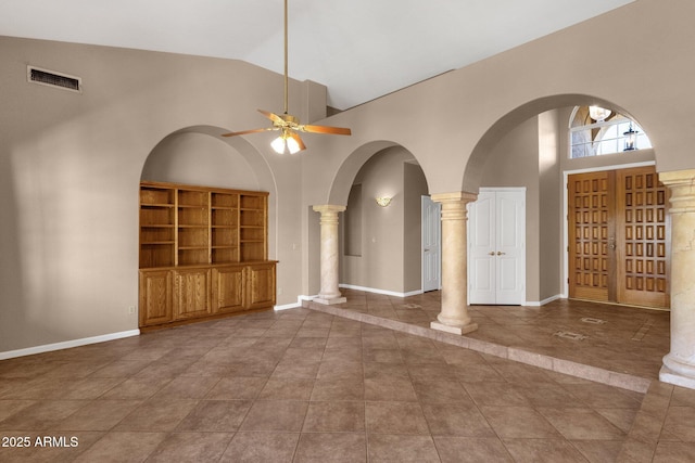 interior space featuring decorative columns, dark tile patterned floors, high vaulted ceiling, and ceiling fan