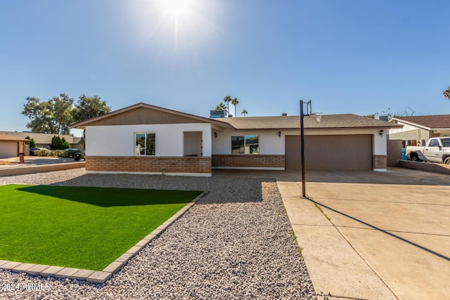 4302 N 80th Ln, Phoenix, AZ 85033 - single story home with brick siding, a garage, concrete driveway, a front yard, and stucco siding