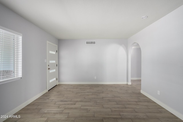 4302 N 80th Ln, Phoenix, AZ 85033 - unfurnished room featuring wood finished floors, arched walkways, and baseboards