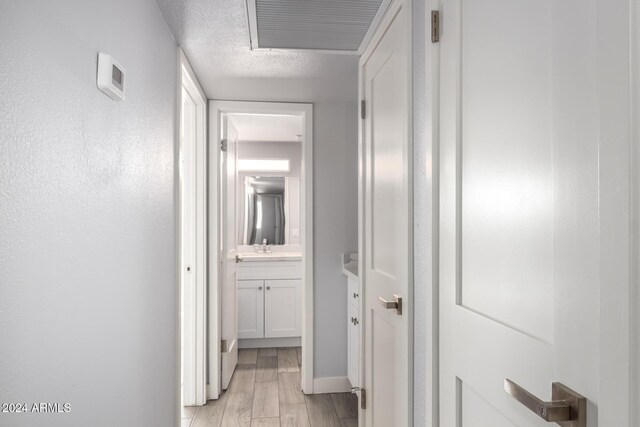 4302 N 80th Ln, Phoenix, AZ 85033 - hallway featuring baseboards, light wood finished floors, and a sink