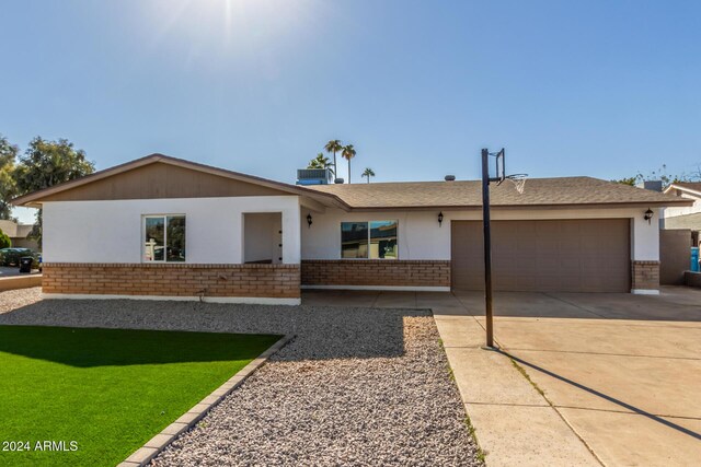 4302 N 80th Ln, Phoenix, AZ 85033 - view of front facade featuring brick siding, an attached garage, driveway, and stucco siding