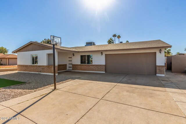 4302 N 80th Ln, Phoenix, AZ 85033 - ranch-style house with an attached garage, brick siding, driveway, and stucco siding