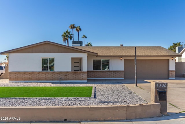 4302 N 80th Ln, Phoenix, AZ 85033 - ranch-style house with brick siding, concrete driveway, and an attached garage