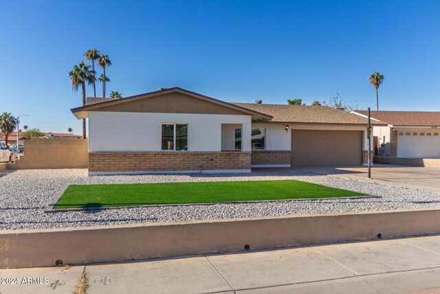 4302 N 80th Ln, Phoenix, AZ 85033 - single story home with a garage, brick siding, driveway, and a front yard