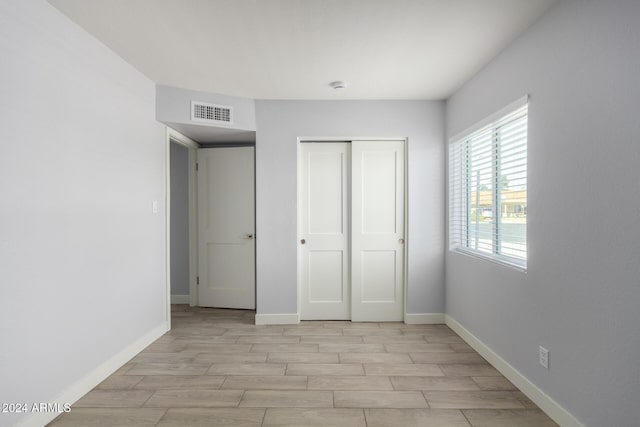 4302 N 80th Ln, Phoenix, AZ 85033 - unfurnished bedroom featuring light wood-type flooring, a closet, and baseboards