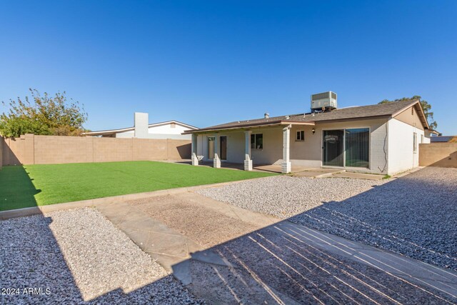 4302 N 80th Ln, Phoenix, AZ 85033 - back of property featuring a patio, cooling unit, brick siding, and a shingled roof