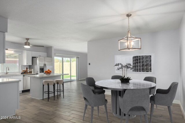 4302 N 80th Ln, Phoenix, AZ 85033 - dining space featuring light wood finished floors, a chandelier, a ceiling fan, and baseboards