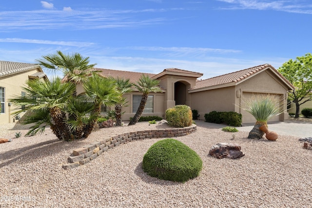 mediterranean / spanish-style home featuring stucco siding, an attached garage, driveway, and a tile roof