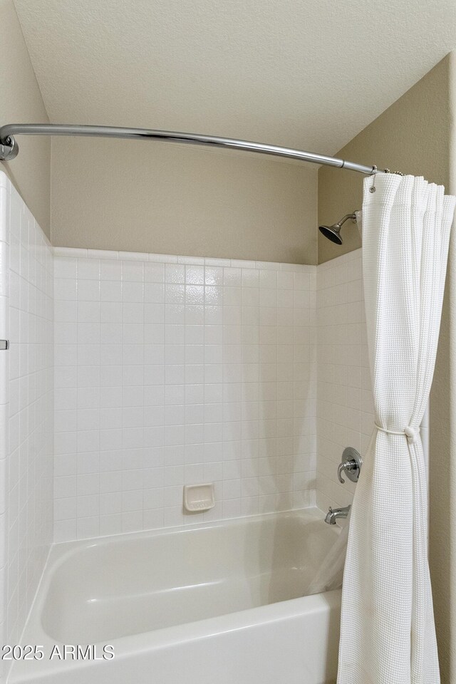 full bathroom featuring shower / tub combo and a textured ceiling