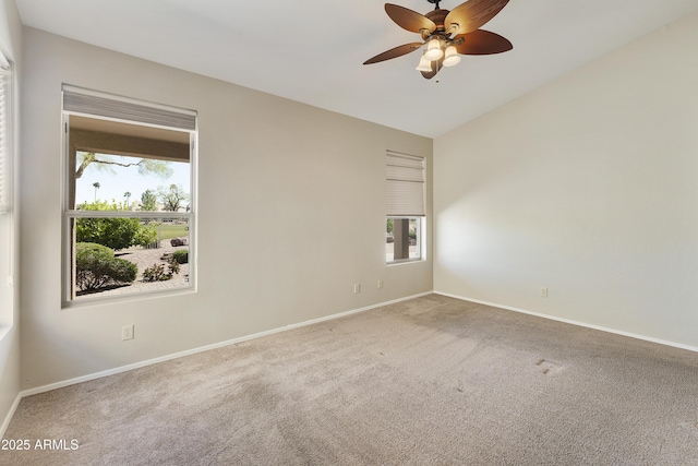 carpeted empty room featuring baseboards and a ceiling fan