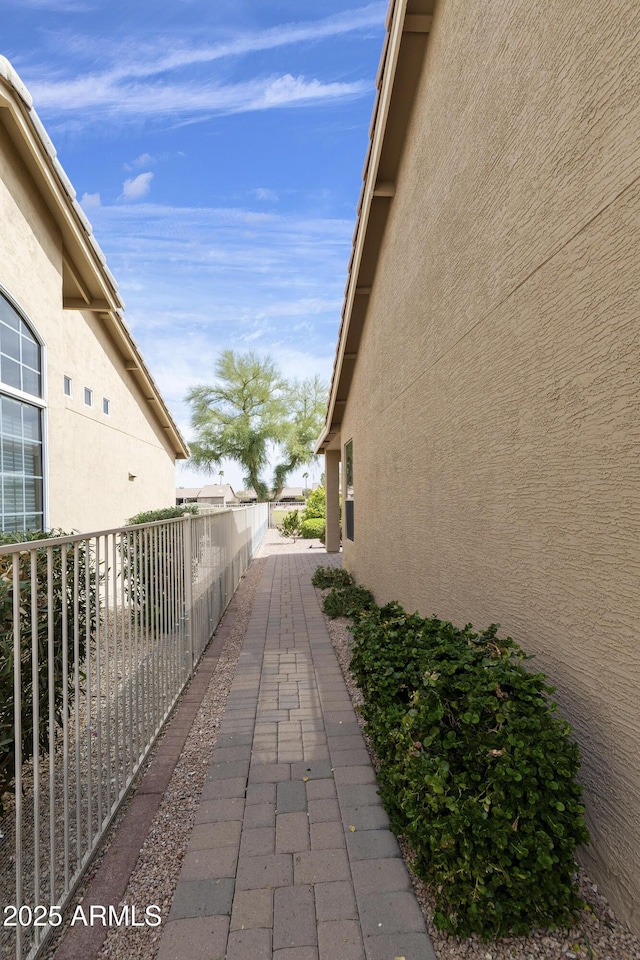 view of home's exterior featuring stucco siding and fence