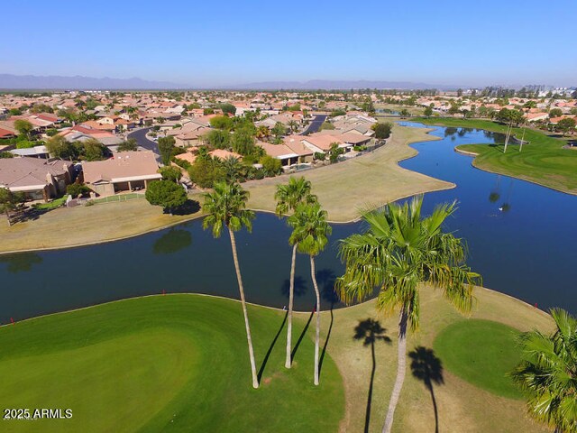 drone / aerial view with golf course view, a water view, and a residential view