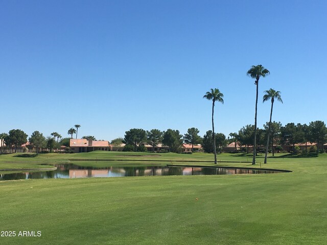 view of home's community featuring a lawn and a water view