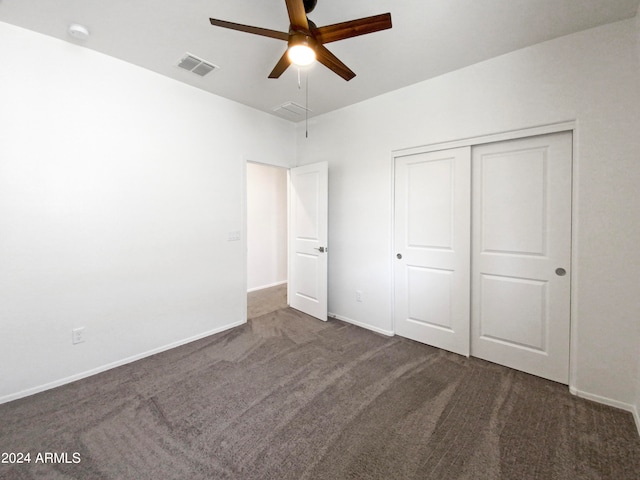 unfurnished bedroom featuring dark carpet, a closet, and ceiling fan