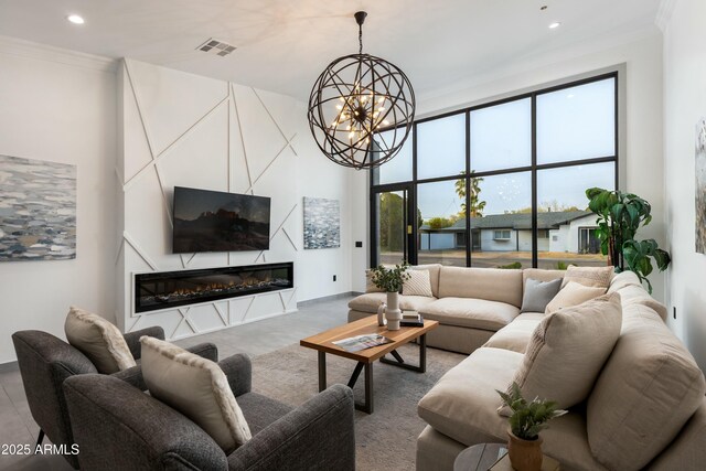 living area with recessed lighting, a notable chandelier, visible vents, a glass covered fireplace, and crown molding