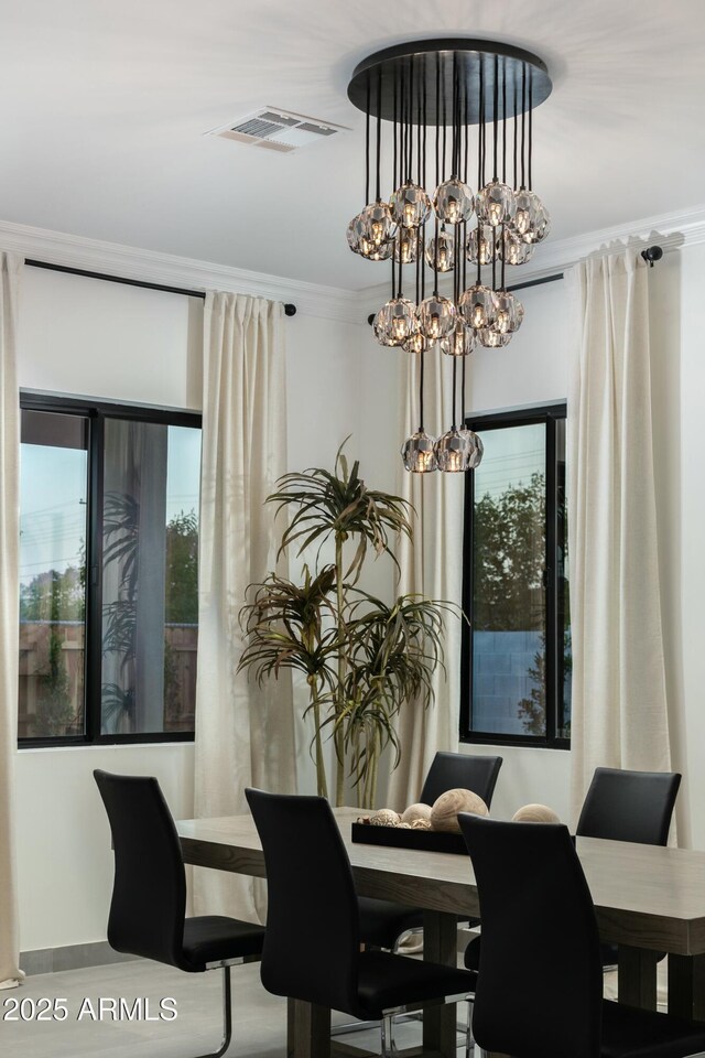 dining room with ornamental molding, a chandelier, and visible vents