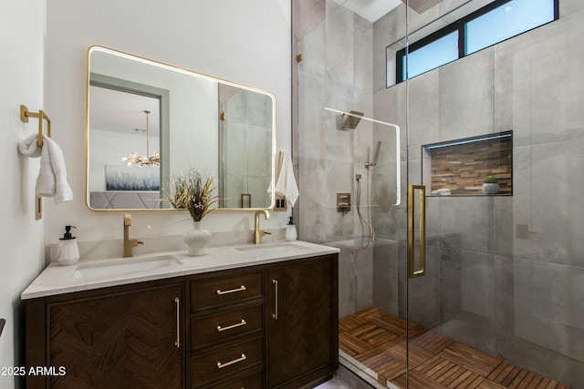 full bathroom with a sink, a shower stall, and double vanity