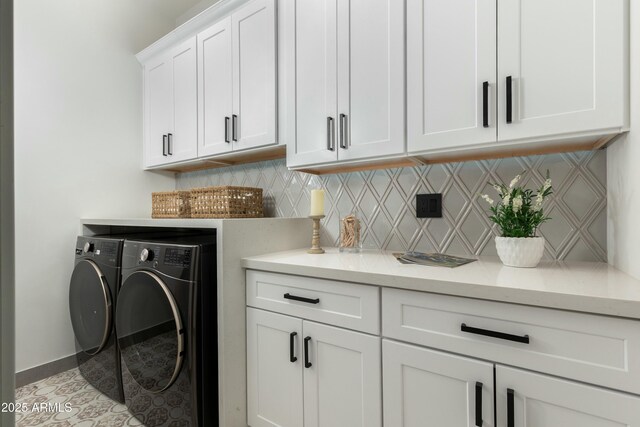 washroom with tile patterned floors, washing machine and clothes dryer, cabinet space, and baseboards