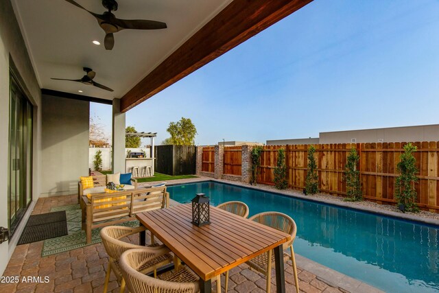 view of swimming pool with a fenced backyard, a ceiling fan, a fenced in pool, outdoor dining space, and a patio area