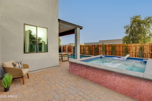 view of swimming pool with an in ground hot tub, fence, a fenced in pool, and a patio