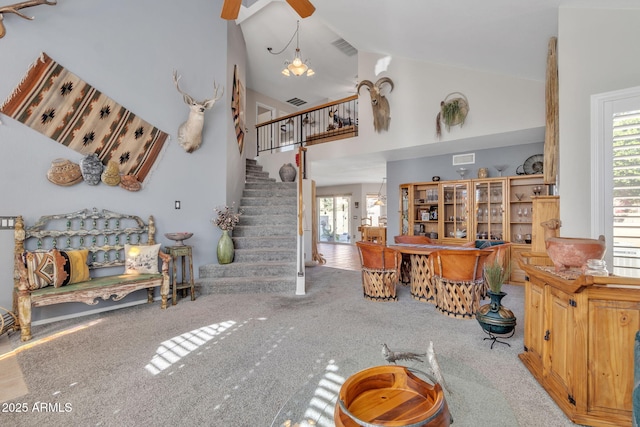 carpeted living room with a healthy amount of sunlight, high vaulted ceiling, and ceiling fan