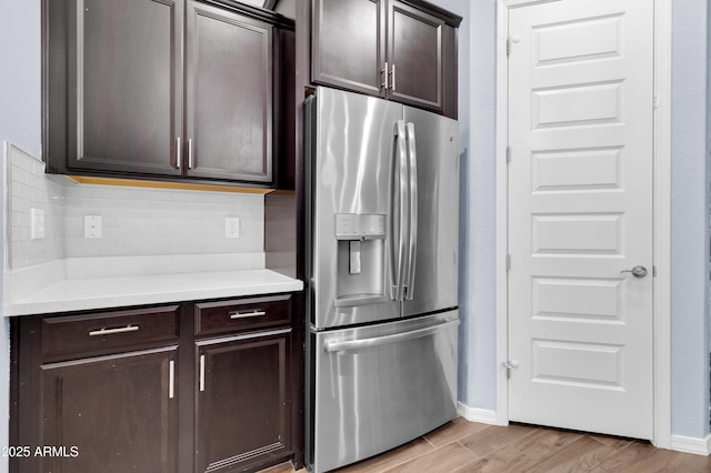 kitchen featuring decorative backsplash, dark brown cabinets, and stainless steel refrigerator with ice dispenser