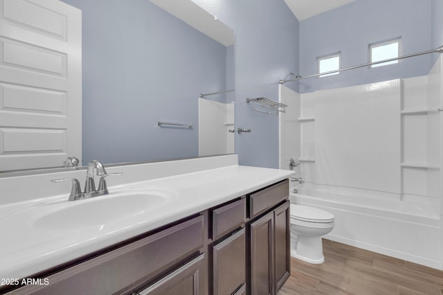 bathroom with shower / bath combination, toilet, wood finished floors, and vanity