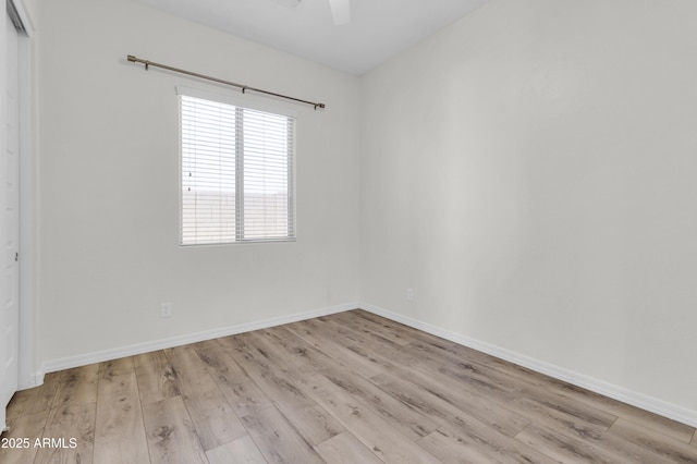 empty room with baseboards, wood finished floors, and a ceiling fan