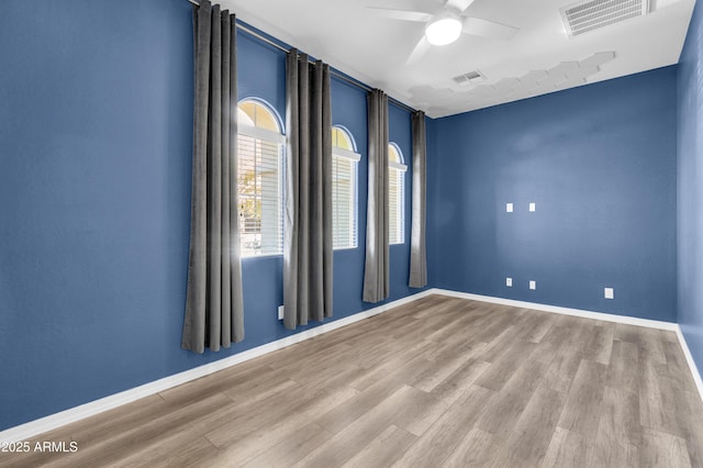 unfurnished room with visible vents, baseboards, and wood finished floors