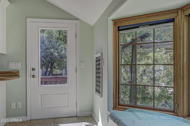 doorway with light tile patterned flooring and lofted ceiling