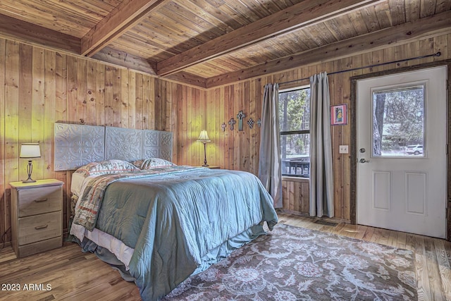 bedroom featuring hardwood / wood-style floors, wooden ceiling, beamed ceiling, and wood walls