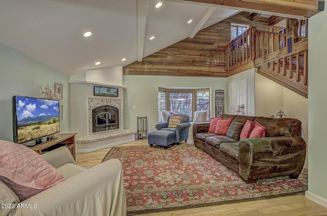 living room featuring beam ceiling, high vaulted ceiling, and light hardwood / wood-style floors